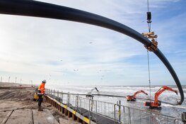Laatste mantelbuis voor windenergie van zee onder duinen door getrokken bij Heemskerk