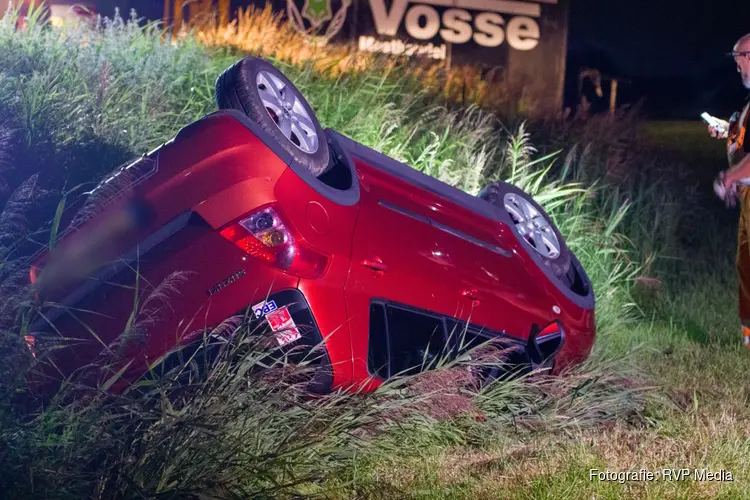 Auto over de kop langs dijk in Beverwijk