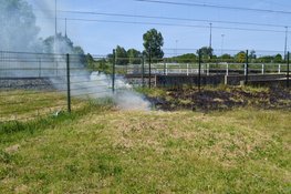 Brandweer blust brandend gras naast spoor Beverwijk